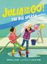 "JULIA ON THE GO! THE BIG SPLASH" in gelber und weißer Schrift. Illustration: Zwei Mädchen mit Wasserschlauch, fröhliches Spiel., Buch