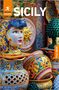 Text: "ROUGH GUIDES", "SICILY", "Free eBook". Bunt bemalte Keramiken und Dekorationen, darunter ein Gesicht und Sonnensymbol., Buch