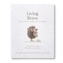 Text: "Living Brave. How to add more confidence to your courage." Igel-Illustration auf Steinen, strahlenförmige Linien., Buch