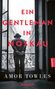 "Ein Gentleman in Moskau", von Amor Towles. Eine Person steht in einem offenen Fenster, sieht hinaus auf eine Stadt., Buch