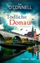"Tödliche Donau: Kriminalroman" von Pia O'Connell. Eine alte Steinbrücke mit einer Stadt im Hintergrund, Vögel fliegen., Buch