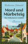 „Katharina Schendel: Mord und Mürbeteig. Miss Molly Spencer ermittelt. Ein Cornwall-Krimi.“ Illustration eines Dorfes mit Hund., Buch