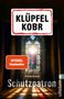 "Klüpfel Kobr", "Kriminalroman Schutzpatron" auf einem farbigen Kirchenfenster mit Heiligenbild und Lichtstrahlen., Buch