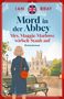 Titel: "Mord in der Abbey". Untertitel: "Mrs. Maggie Marlowe wirbelt Staub auf". Frau im Trenchcoat schaut auf alte Abtei., Buch