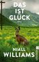 „Das ist Glück, Roman, Niall Williams“. Ein Hase auf einer Wiese vor grünen Bergen, links ein Strommast.