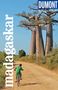 „madagaskar“ und „DUMONT Reise-Taschenbuch“. Ein Kind fährt auf einem sandigen Weg mit dem Fahrrad an großen Baobab-Bäumen vorbei., Buch