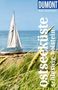 „Ostseeküste Schleswig-Holstein“ in großer Schrift, oben „DuMont Reise-Taschenbuch“. Segelboot am Strand mit Gräsern., Buch