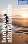 „bordeaux & atlantikküste“ steht groß senkrecht. Oben rechts ist ein „DUMONT Reise-Taschenbuch“ Logo, unten ein Sonnenuntergang am Strand., Buch