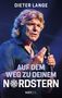 “DIETER LANGE. AUF DEM WEG ZU DEINEM NORDSTERN. NXT LVL.” Mann spricht ins Mikrofon, blau-violettes Licht., Buch
