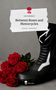 Text: "Between Roses and Motorcycles." Rote Rosen und ein schwarzer Motorradstiefel auf grauem Hintergrund., Buch