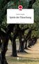 „Spiele der Täuschung“ von Nadine Fengler. Eine Allee aus alten, knorrigen Bäumen in einer sonnigen Umgebung., Buch