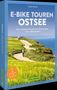Buchtitel: "E-Bike Touren Ostsee" von Georg Weindl. Zwei Radfahrer auf einem Weg an der Küste entlang eines grünen Feldes., Buch
