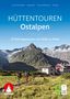 "Hüttentouren Ostalpen. 32 Mehrtagestouren von Hütte zu Hütte." Zwei Wanderer, Berglandschaft, Hütten, ROTHER-Logo.