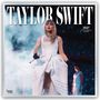 Text oben: "TAYLOR SWIFT". Text rechts: "2027 OFFICIAL 16-MONTH CALENDAR". Frau im weißen Kleid mit Mikrofon vor Publikum.