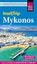 "Insel|Trip Mykonos" von Markus Bingel. Bild einer Küste mit weißen Gebäuden und Booten im blauen Wasser.