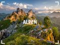 „ALPEN 2027“ steht im Vordergrund einer malerischen Berglandschaft mit felsigen Gipfeln und üppigem Grün im Abendlicht., Kalender