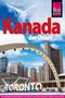 "Kanada der Osten" in Rot und Weiß, mit "TORONTO" in großen Buchstaben. Skyline mit blauem Himmel und modernen Gebäuden.