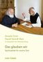 Anselm Grün, David Steindl-Rast: "Das glauben wir". Zwei Männer, auf einem Holzschreibtisch sitzend, im Gespräch., Buch