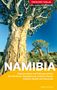 "Trescher Verlag, Mehr Wissen, Besser Reisen. Namibia. Naturparadiese und Kulturgeschichte. Mit Windhoek, Swakopmund, Lüderitz, Etosha, Kalahari, Namib und Sossusvlei. Fabian von Poser." Darunter Kalahari Landschaft mit blühenden Pflanzen und Bäumen unter klarem Himmel., Buch
