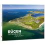 „RÜGEN OSTSEEBLICKE Luftaufnahmen“. Luftaufnahme einer Küste mit blauem Meer und grünen Feldern., Buch