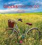 "Glücksmomente 2026". Ein Fahrrad steht in einem blühenden Feld unter blauem Himmel. Unten ein Logo von Magdalenen.