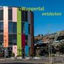 „Wuppertal entdecken“ in gelber Schrift, moderner Bau mit bunten Fassaden und Schwebebahn auf Stahlkonstruktion., Buch