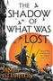 "The Shadow of What Was Lost" oben. "James Islington" unten. Personen mit Stäben vor oranger Sonne. Gebäude links. Vögel fliegen.