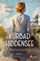 „Kurbad Hiddensee: Meeresleuchten“. Frau in Streifenkleid schaut aufs Meer, im Hintergrund ein großes Gebäude., Buch