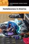 "Homelessness in America" von Michele Wakin. Zwei Personen schlafen zusammengekauert auf der Straße, umgeben von Habseligkeiten., Buch