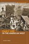 Oben steht "Daily Life in the American West". Eine historische Illustration zeigt Menschen beim Lagerfeuer mit Planwagen., Buch