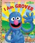 Text: "I Am Grover", "Sesame Street". Illustration eines blauen Charakters mit rosa Nase, fröhlich winkend, im Garten., Buch
