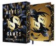 "The Hunger Games" und "Suzanne Collins" auf einem Cover mit zwei schwarzen Vögeln und Federn in einem goldenen Kreis., Buch