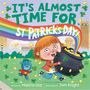 „It’s Almost Time for St Patrick’s Day!“ Ein Kind mit rotem Haar hält einen schwarzen Topf voller Münzen unter einem Regenbogen., Buch