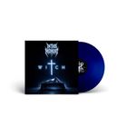 Logo "In This Moment", Text "WITCH". Ein beleuchtetes Kreuz über einem verschleierten Tisch, blaue Vinylplatte sichtbar.