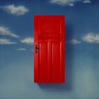 Rote Tür schwebend vor einem wolkigen, blauen Himmel. Simplistisches und surrealistisches Motiv.