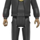 Eine Figur in schwarzer Kleidung mit Weihnachtsmütze, Sonnenbrille und goldener Kette. Ein Mikrofon mit grüner Schleife.