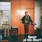 "GoldFord" und "Space of the Heart". Mann lehnt an Holzwand mit Gitarre, daneben Gitarren und Verstärker.