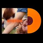Text: "SYSTEM". Ein verschwommenes Bild von Kindern im Gras, links ein oranges Vinyl.