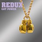 Text: "Redux Cat Power". Goldene Boxhandschuh-Anhänger an einer Kette vor unscharfem Hintergrund.