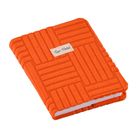 „Quo Vadis“ steht auf einem Etikett. Ein oranges Buch mit strukturiertem Stoffeinband in geometrischem Muster.