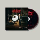 Lilly Wood & The Prick in roter Schrift, Personen in eleganter Kleidung in opulentem Raum, eine CD steht daneben.