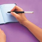 "SECRET NOTES" steht auf einem geöffneten Notizbuch mit blauen Seiten. Eine Hand hält einen Stift, bereit zu schreiben.