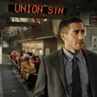 Text "UNION STN" in leuchtend roten Buchstaben. Ein Mann im Anzug in einem Zugabteil mit anderen sitzenden Passagieren.