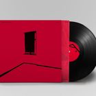 Die Texte „Conrad Schnitzler“ und „Conal“ stehen auf einem roten Albumcover. Es zeigt ein Fenster und geometrische Linien.