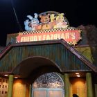 "FREDDY FAZBEAR'S" in roten Buchstaben, darüber Comic-Tiere. Bunte Fassade mit Sternen, beleuchteter Eingang.