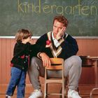Tafel mit "Mr. Kimble's kindergarten". Ein Mann in sportlicher Kleidung sitzt nachdenklich an einem Tisch, neben einem Kind.