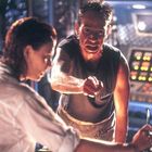 Ein Mann zeigt auf etwas, während eine Frau ihm zuhört. Beide befinden sich offenbar in einem technischen Raum.