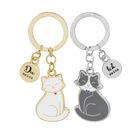 Zwei Schlüsselanhänger mit Katzenmotiven: „Du meins“ auf gold, „Ich deins“ auf silber. Eine weiße, eine graue Katze.