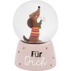 Text: „Für Dich“. Schneekugel mit einem Hund in buntem Pullover, hält eine Blume, steht auf gepunktetem Sockel.