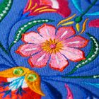 Text ist nicht vorhanden. Eine bunte Stickerei zeigt eine rosa Blume mit gelbem Zentrum auf blauem Hintergrund.